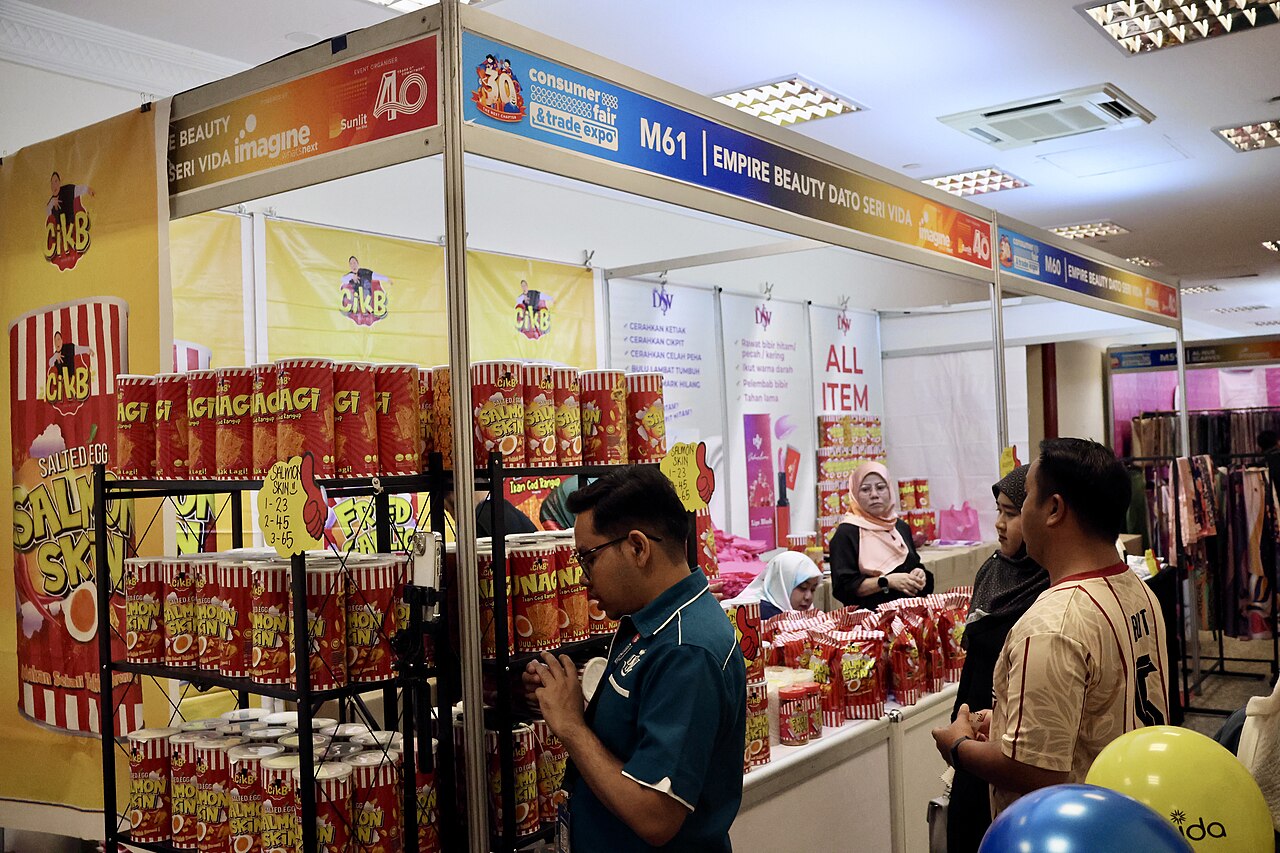 บูธแสดงสินค้าในงานเทรดแฟร์พร้อมพนักงานและผู้เข้าชม