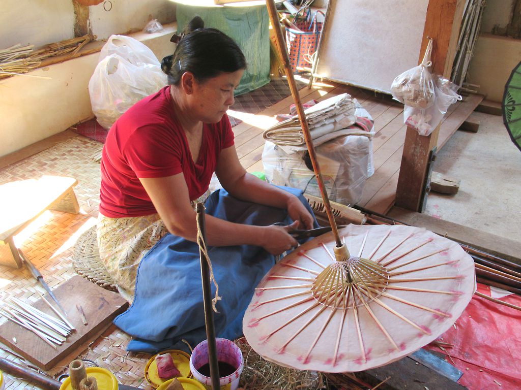 ช่างฝีมือกำลังประกอบโครงร่มไม้ไผ่ด้วยมือ
